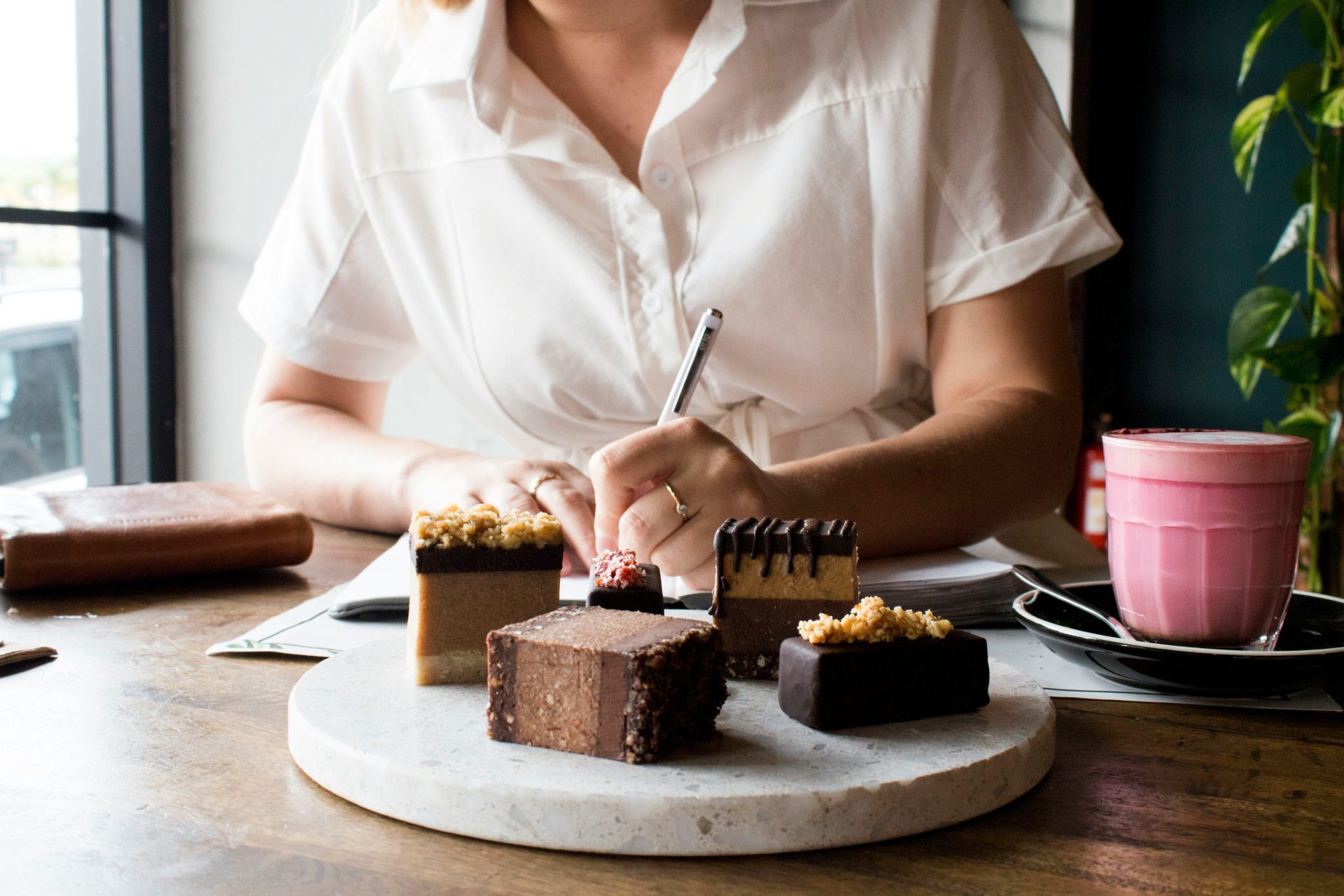 a woman sitting at a table with a plate of desserts