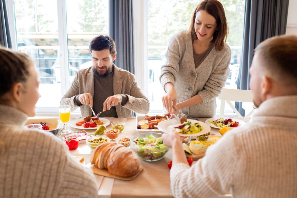 Four friends sharing a delightful meal indoors, highlighting friendship and togetherness.